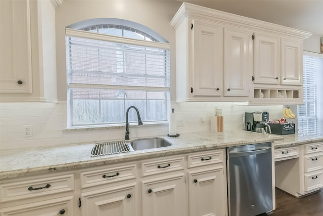 kitchen featuring backsplash, stainless steel dishwasher, a sink, a wealth of natural light, and white cabinetry