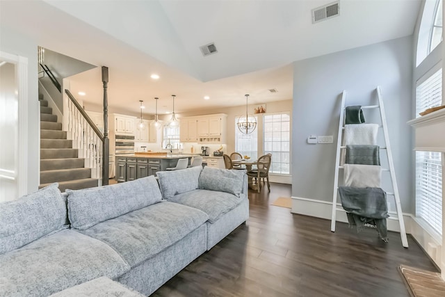 living room featuring plenty of natural light, visible vents, recessed lighting, and dark wood finished floors