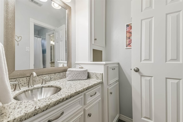 full bath with baseboards, visible vents, and vanity