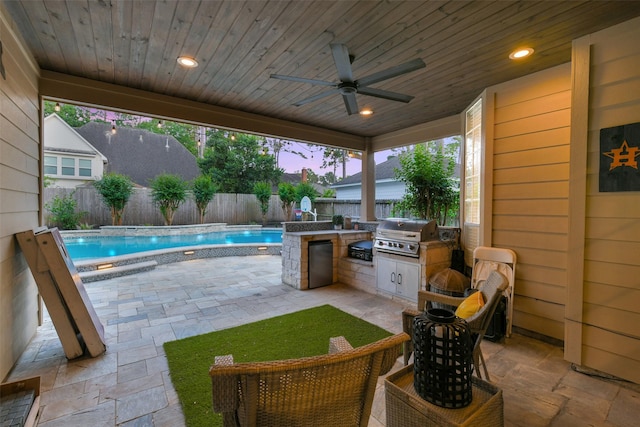 patio terrace at dusk featuring a fenced in pool, a ceiling fan, exterior kitchen, a fenced backyard, and grilling area