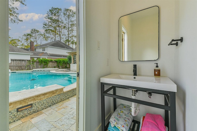 bathroom with stone tile flooring, plenty of natural light, and a sink