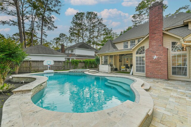 view of swimming pool featuring a pool with connected hot tub, a fenced backyard, and a patio