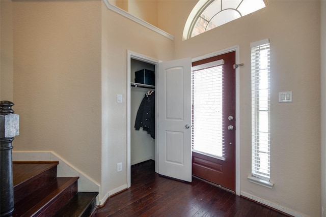 entrance foyer featuring baseboards, stairs, and dark wood-style flooring