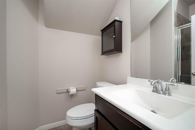 bathroom with baseboards, a stall shower, toilet, and vanity
