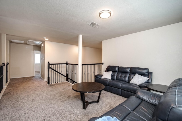 carpeted living area with visible vents and attic access