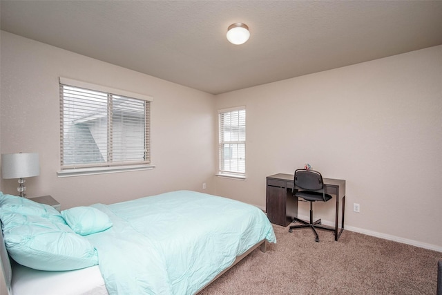 bedroom featuring light colored carpet and baseboards