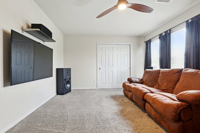 living room featuring visible vents, carpet flooring, baseboards, and ceiling fan