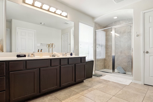 full bath featuring a sink, double vanity, visible vents, tile patterned flooring, and a shower stall