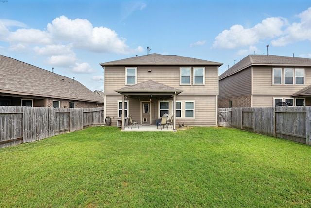 back of property featuring a yard, a patio area, and a fenced backyard