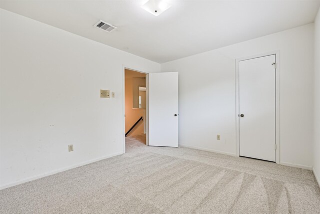 unfurnished room featuring visible vents, baseboards, and light carpet