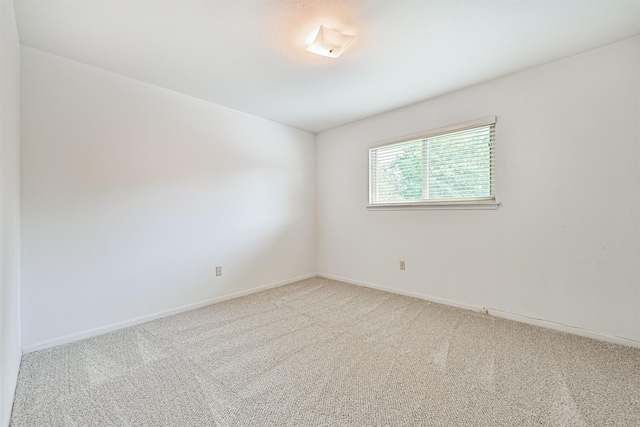 empty room featuring baseboards and carpet