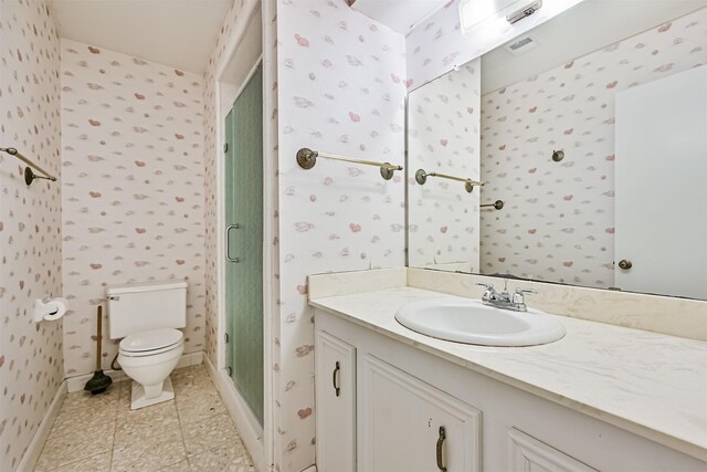 bathroom featuring vanity, toilet, baseboards, wallpapered walls, and a shower stall