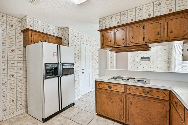 kitchen with brown cabinetry, light countertops, and white appliances