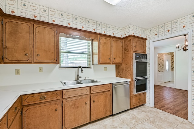 kitchen featuring a sink, light countertops, dobule oven black, and dishwasher
