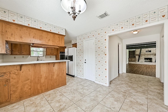 4206 Willow Hill Dr, Seabrook, TX 77586 - kitchen featuring visible vents, white refrigerator with ice dispenser, a sink, light countertops, and a peninsula