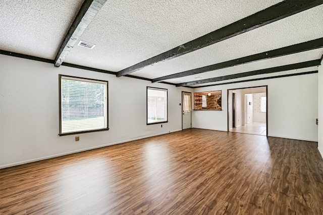 4206 Willow Hill Dr, Seabrook, TX 77586 - spare room featuring wood finished floors, a textured ceiling, beam ceiling, and a healthy amount of sunlight
