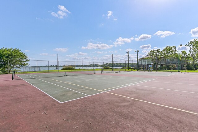 view of tennis court featuring fence and community basketball court