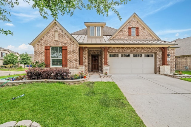 view of front of home featuring brick siding, a standing seam roof, a garage, and a front yard