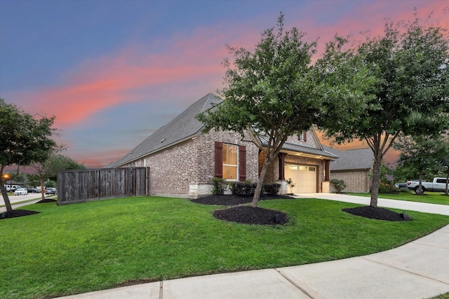 view of front facade featuring driveway, brick siding, a yard, and a garage