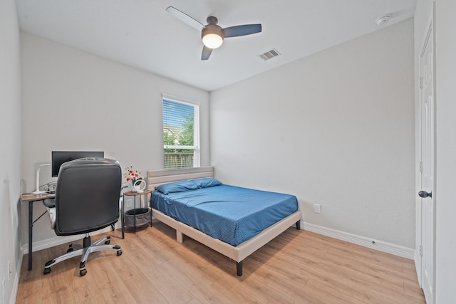 bedroom featuring baseboards, wood finished floors, visible vents, and ceiling fan