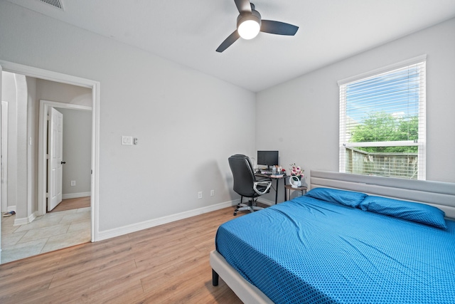 bedroom featuring light wood finished floors, baseboards, and ceiling fan