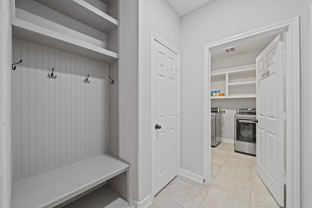 mudroom with separate washer and dryer, baseboards, and light tile patterned flooring