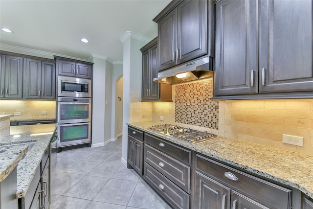 kitchen with stainless steel appliances, arched walkways, baseboards, under cabinet range hood, and ornamental molding