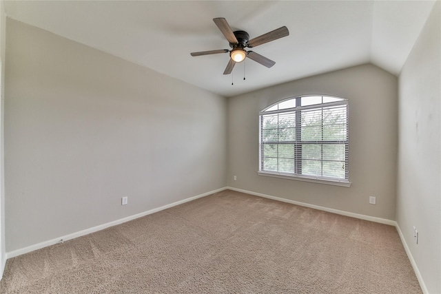 spare room with light colored carpet, baseboards, a ceiling fan, and vaulted ceiling