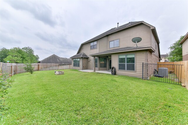 rear view of property with a fenced backyard, a yard, central air condition unit, a patio, and brick siding
