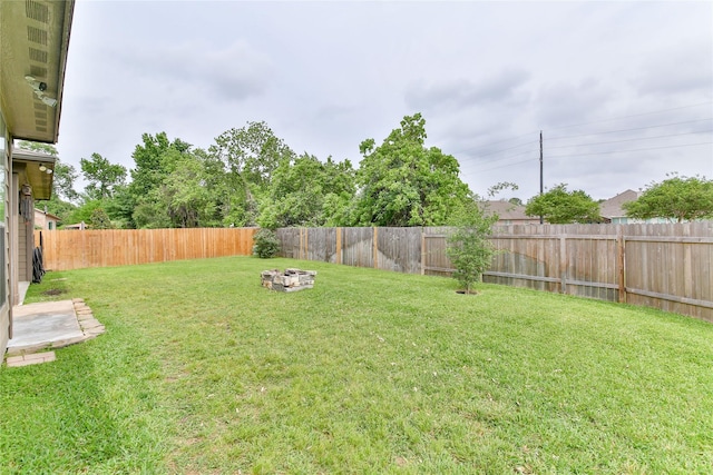 view of yard with a fenced backyard and an outdoor fire pit