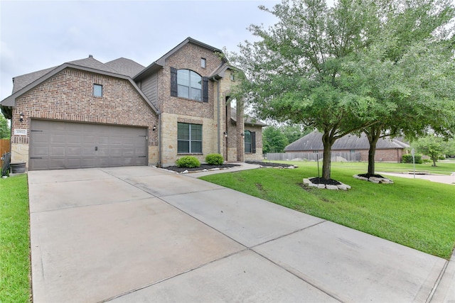 traditional home with an attached garage, driveway, brick siding, and a front yard