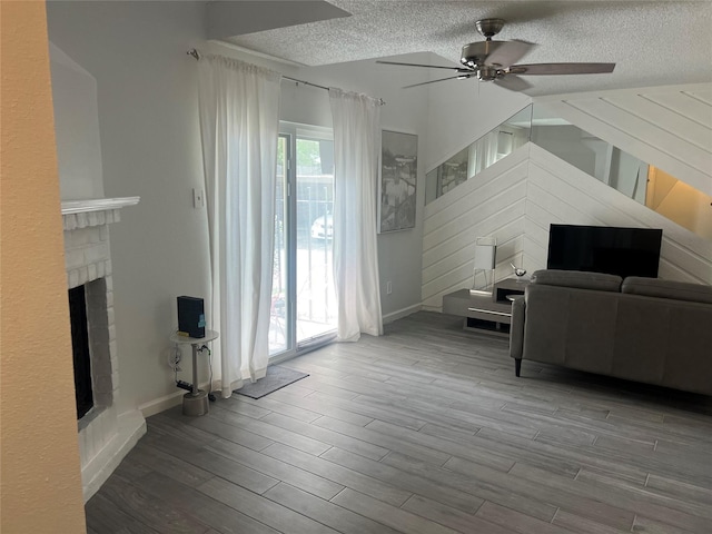 2800 Jeanetta St Unit 2104, Houston, TX 77063 - living room featuring wood finished floors, baseboards, a fireplace, a textured ceiling, and ceiling fan