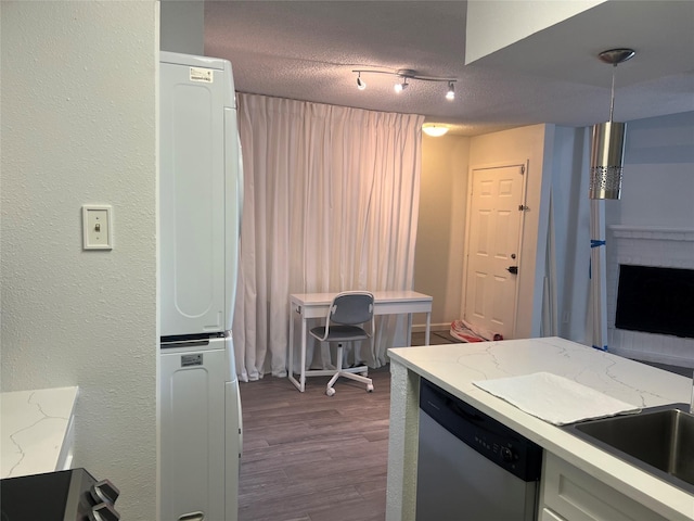 2800 Jeanetta St Unit 2104, Houston, TX 77063 - kitchen featuring stacked washer and dryer, stainless steel dishwasher, dark wood-style floors, a textured ceiling, and light stone counters