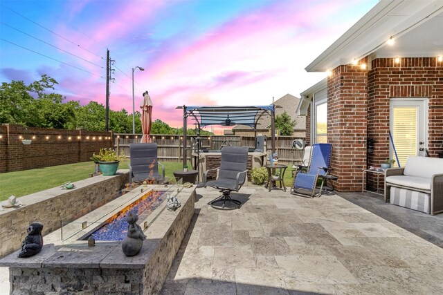7407 Tudor Heights Ln, Spring, TX 77379 - patio terrace at dusk with a fire pit, a patio, and a fenced backyard