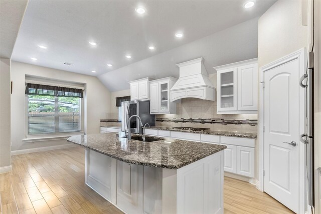 7407 Tudor Heights Ln, Spring, TX 77379 - kitchen with a sink, custom range hood, appliances with stainless steel finishes, a center island with sink, and tasteful backsplash