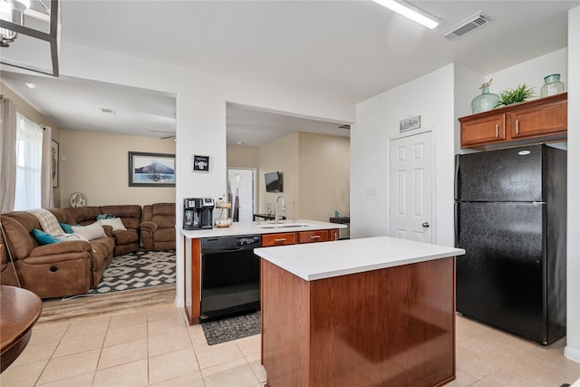 kitchen featuring a sink, open floor plan, visible vents, light countertops, and black appliances