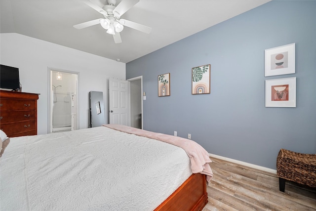 bedroom featuring wood finished floors, ensuite bath, baseboards, and ceiling fan