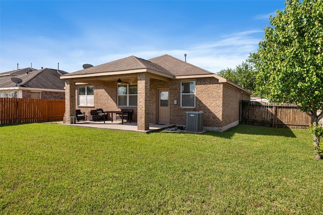 back of house with brick siding, a yard, central air condition unit, and a patio