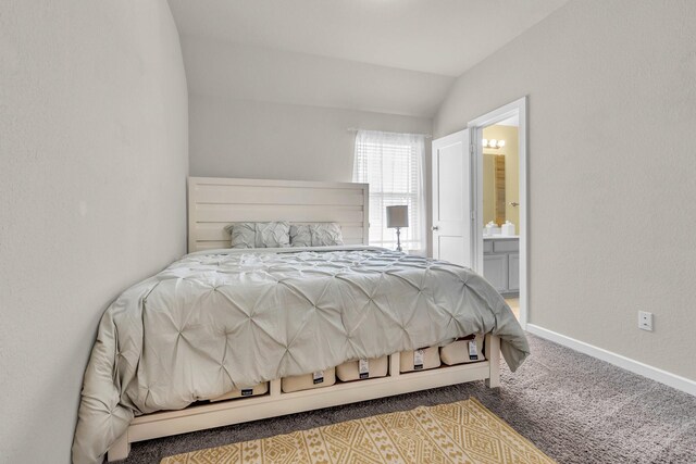 bedroom featuring ensuite bathroom, lofted ceiling, carpet floors, and baseboards