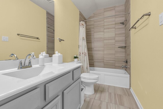 bathroom featuring shower / bathtub combination with curtain, vanity, toilet, and vaulted ceiling
