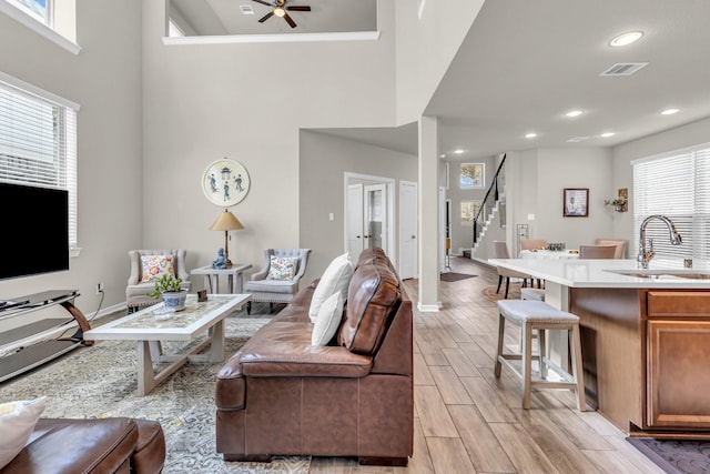 living room with visible vents, baseboards, recessed lighting, a ceiling fan, and stairs