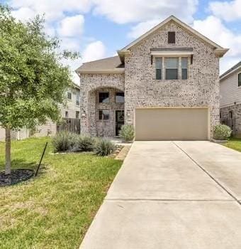 french country home featuring a front lawn, driveway, a garage, and brick siding