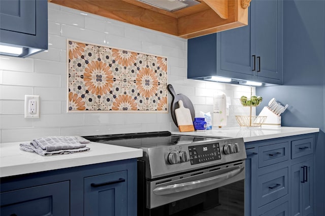 kitchen featuring blue cabinets, stainless steel electric stove, light countertops, and backsplash