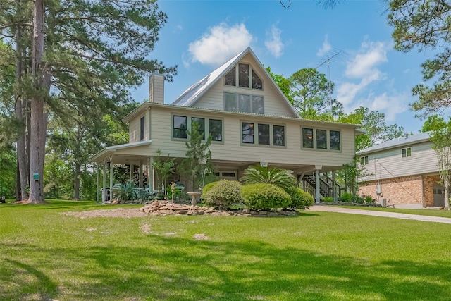 view of front facade with stairway, driveway, a front lawn, and a carport