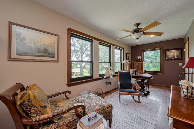 office area with wood finished floors, a textured ceiling, baseboards, and ceiling fan