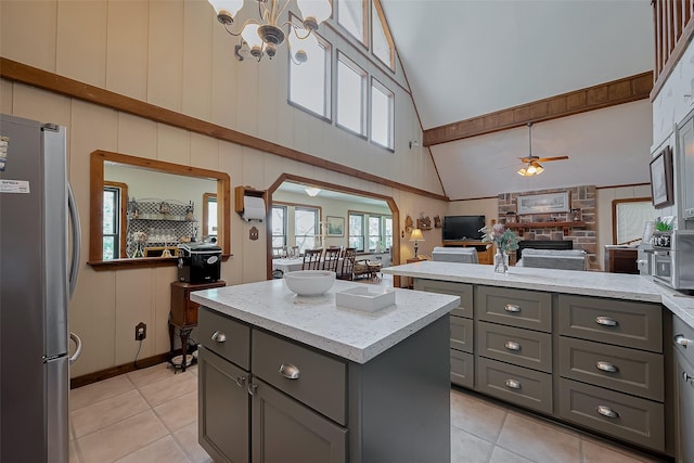 kitchen featuring open floor plan, freestanding refrigerator, gray cabinetry, high vaulted ceiling, and light tile patterned floors