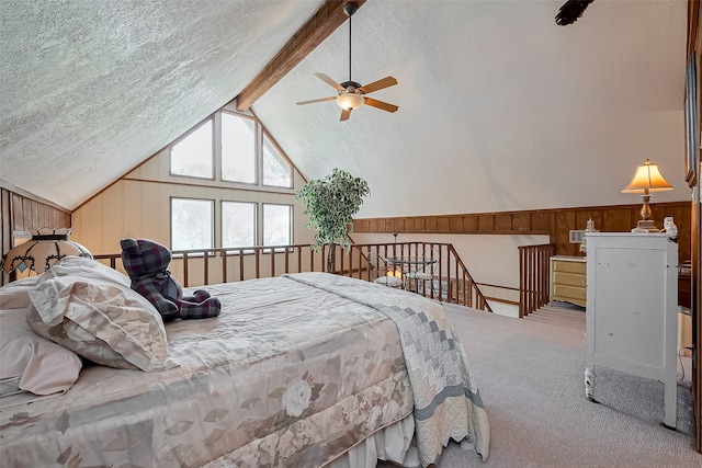 bedroom with wooden walls, a textured ceiling, carpet flooring, and vaulted ceiling with beams