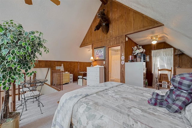 bedroom featuring a textured ceiling, lofted ceiling, carpet flooring, and wood walls