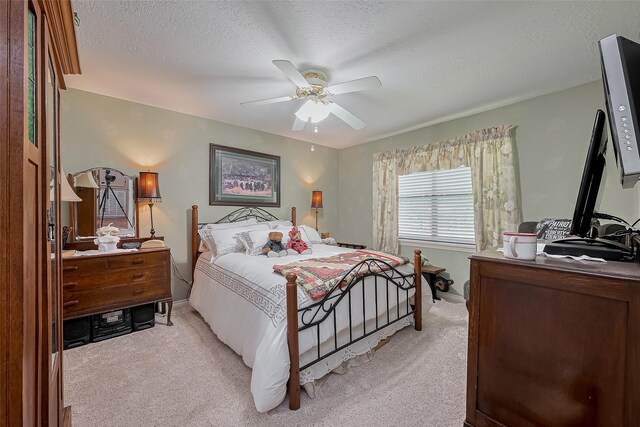 bedroom with baseboards, a textured ceiling, light colored carpet, and ceiling fan
