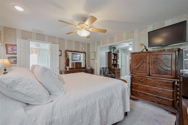 carpeted bedroom with a ceiling fan, visible vents, and wallpapered walls